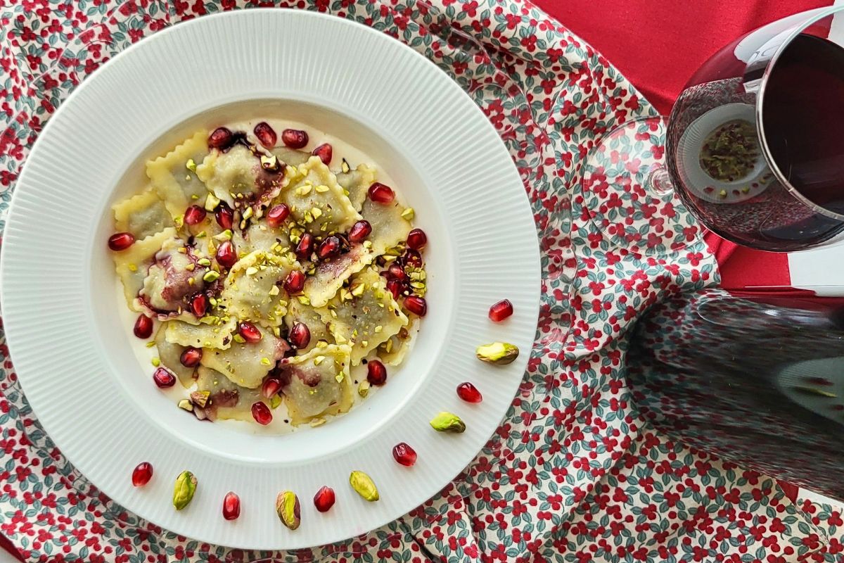 Agnolotti-in-fonduta-di-Parmigiano-con-riduzione-al-vino-rosso-pistacchi-e-melagrana